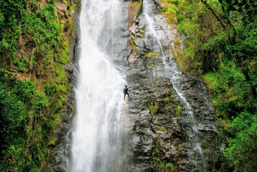 Aventureiro descendo cachoeira com cordas