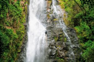 Aventureiro descendo cachoeira com cordas